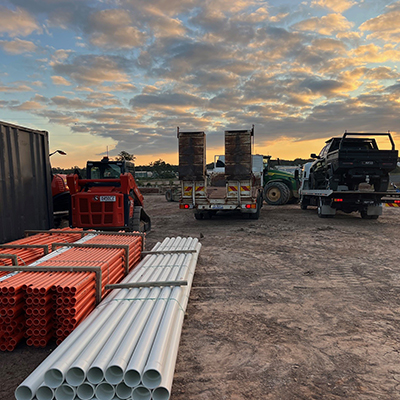 A truck parked beside a large pile of pipes, representing Huff Group's construction delivery services