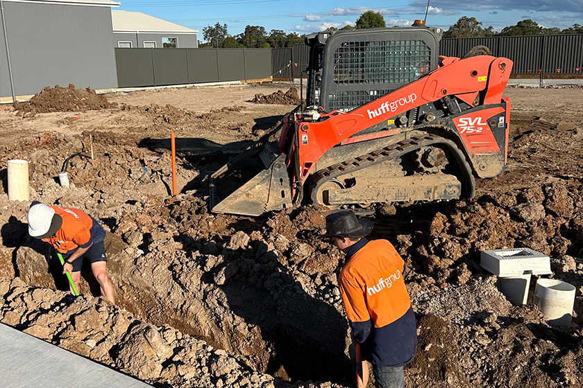Workers from Huff Group excavate a trench at a construction site for civil electrical services
