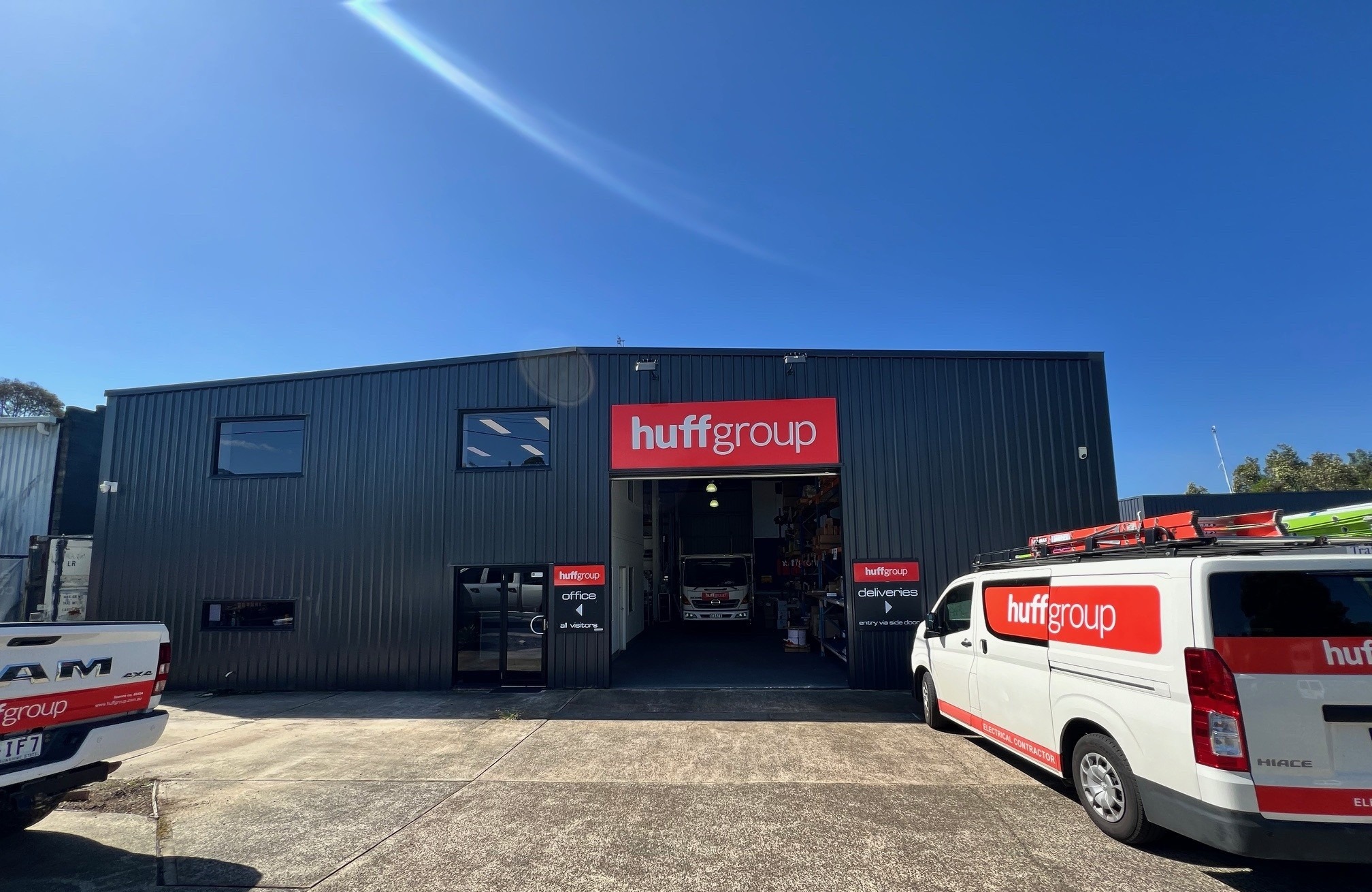 A white, logo-branded service vehicle parked outside Huff Group headquarters in Maroochydore